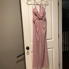 a pink dress hanging on a white door