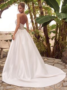 a woman in a wedding dress standing on a stone walkway