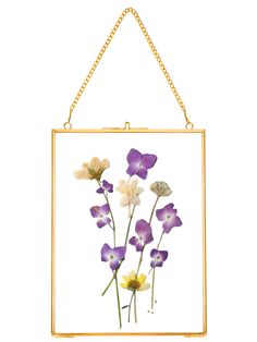 purple and white flowers are displayed in a gold frame hanging on a wall or ceiling