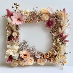 a white frame decorated with flowers and plants