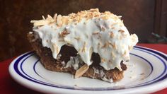 a piece of cake with white frosting and nuts on top sitting on a plate