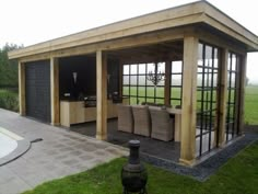 an outdoor living area with couches and tables in the grass next to a swimming pool