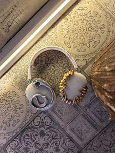 a pair of headphones sitting on top of a tiled floor next to a lamp