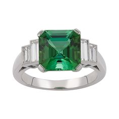 E Wolfe & Company Handmade 18ct White Gold Green Tourmaline and Diamond Baguette Ring. The green tourmaline centre stone weighs 3.59 carats and has two pairs of baguettes diamonds set to either side. The baguette diamonds have a total weight of .73 carats and are of G colour and VS clarity. The ring was handmade at our London Workshop during 2021 and it weighs 5.14 grams. Currently the ring is a British finger size K 1/2 but it can be increased or reduced in size as is required. Luxury Emerald Ring With Baguette Cut And Accent Stones, Formal Green Polished Gemstones, Timeless Baguette Cut Green Emerald Ring, Timeless Green Baguette Cut Emerald Ring, Timeless Green Baguette-cut Emerald Ring, Timeless Green Jewelry With Baguette Diamonds, Elegant Green Gemstones In Platinum Setting, Green Platinum Gemstones Fine Jewelry, Elegant Green Gemstones In Platinum