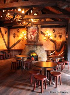 a restaurant with wooden tables and stools next to a fire place in the fireplace