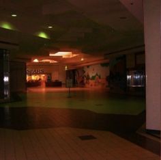 an empty shopping mall with lights on the ceiling and signs in the windows that say sears