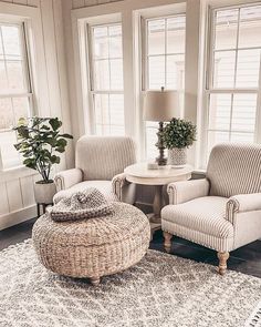 a living room with two chairs and a round ottoman