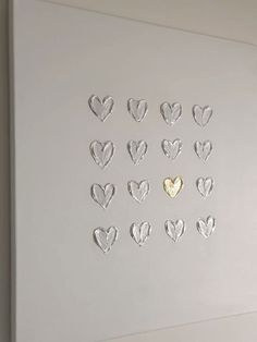 a white wall with hearts cut out of it and a gold heart in the middle