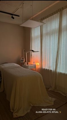 a bed sitting next to a window in a room with curtains on the windowsill