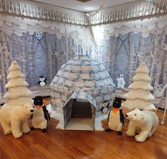 an igloose with polar bears and penguins in front of it on a wooden floor