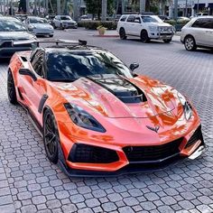 an orange sports car is parked on the street