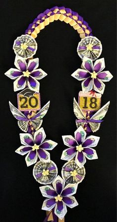 a necklace made out of money and flowers on a black background with the number twenty