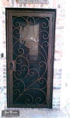 an ornate iron door on a brick wall