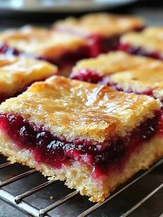 several pieces of pie sitting on top of a cooling rack with blueberry toppings