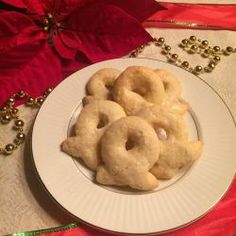 a white plate topped with doughnuts next to a red and gold christmas decoration