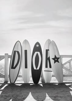 four surfboards are lined up in front of each other with the word dior written on them