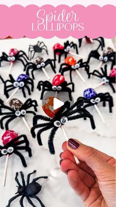 spider lollipops are being held up by someone's hand with their fingers