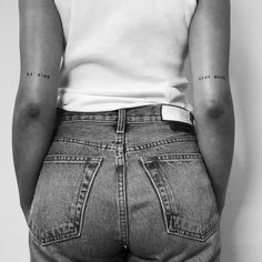 the back of a woman's jeans with small tattoos