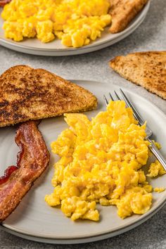 two plates with eggs, toast and bacon on them