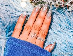 a woman's hand with two rings on it and some decorations in the background