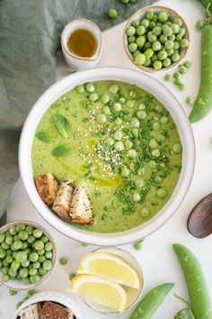 peas, lemons and other foods are in bowls on a table