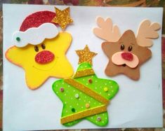 three decorated christmas cookies sitting on top of a piece of paper