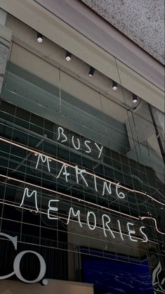 the words busy marking memories are written on the glass front of a storefront window