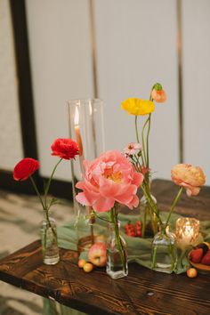 flowers in glass vases on a table with candles and other items around them,