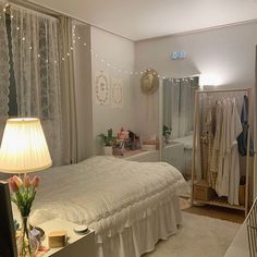 a bedroom with white bedding and curtains