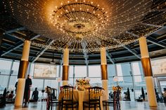 a dining room with lights hanging from the ceiling and tables set up for an event