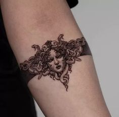 a woman's arm with a tattoo design on the left side of her arm