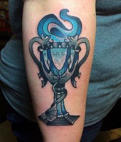 a man with a tattoo on his arm has a blue cup in the shape of a snake