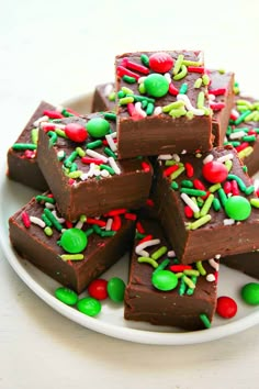 a white plate topped with brownies covered in sprinkles and candies