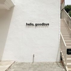 the words hello, goodbye are written in black on a white wall next to stairs