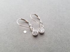 "These tiny sterling silver earrings earrings are small, simple and great for every day wear! A crystal clear CZ circle measuring aprox 5mm hangs from sterling silver leverback or french earwires. The total length of these earrings is almost 1\". Earrings will arrive in a small zip lock bag. It is recommended that the earrings are kept in the bag when not being worn to keep them nice and shiny. Of course, a quick polish will always work too :-) Please let me know if you have any questions!" Silver Round Cut Earrings With Lever Back Ear Wires, Classic Silver Lever Back Earrings, Silver Round Cut Earrings With Lever Back, Silver Round Earrings With Lever Back, Silver Round Lever Back Earrings, Round Silver Lever Back Earrings, Zip Lock Bag, Earrings Round, Silver Bow