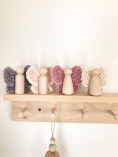 a row of knitted angel figurines sitting on top of a wooden shelf