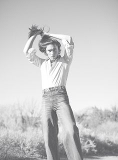 a man standing on top of a skateboard in the middle of a desert area