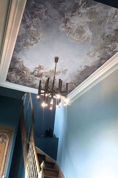 the ceiling is painted with blue paint and chandelier lights are hanging from it