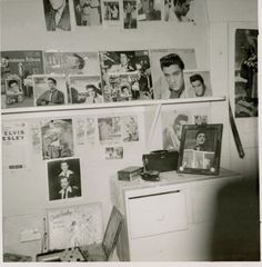 an old black and white photo of a man in his dorm room with pictures on the wall