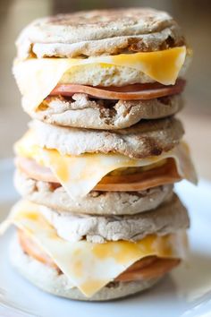 a stack of food sitting on top of a white plate covered in cheese and meat