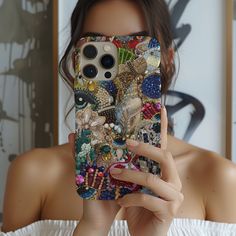 a woman taking a selfie with her cell phone case covered in many different things