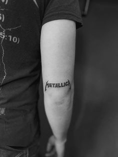 a person with a tattoo on their arm that says metallick in black and white