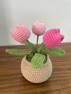 three crocheted flowers in a vase on a table