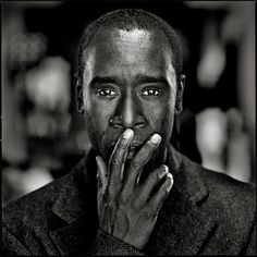 a black and white photo of a man holding his hand to his mouth