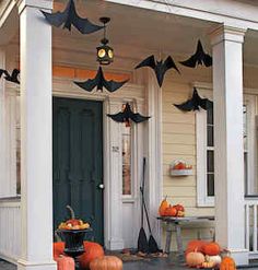 a porch decorated for halloween with pumpkins and bats