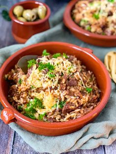 two red bowls filled with rice and vegetables