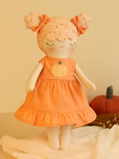 a stuffed doll with an orange dress on