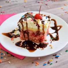 a piece of cake on a plate with chocolate sauce and sprinkles