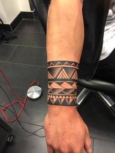 a man's arm with a tattoo on it that has an arrow and triangles