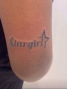 a person with a star tattoo on their arm and the word stargirl written in cursive ink